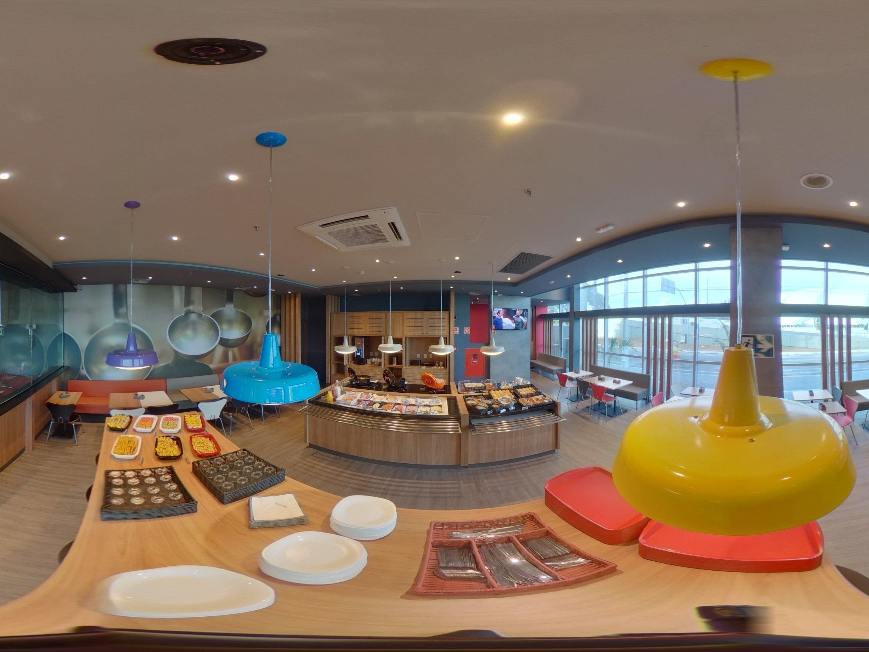 Un restaurante moderno con una barra central, zona de mesas y amplios ventanales.