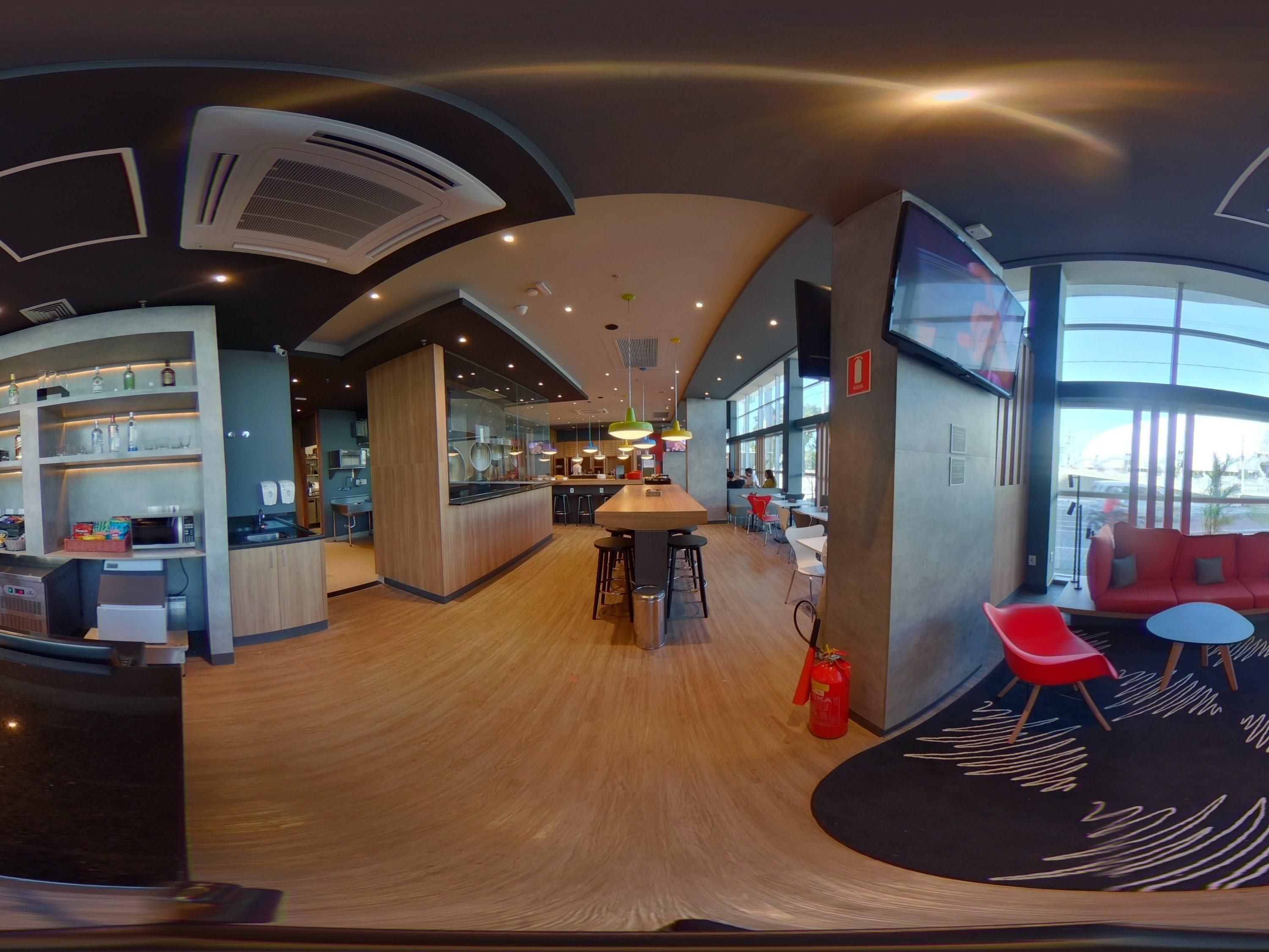 Een modern interieur met een centraal eiland, een bar, zitplaatsen en grote ramen.