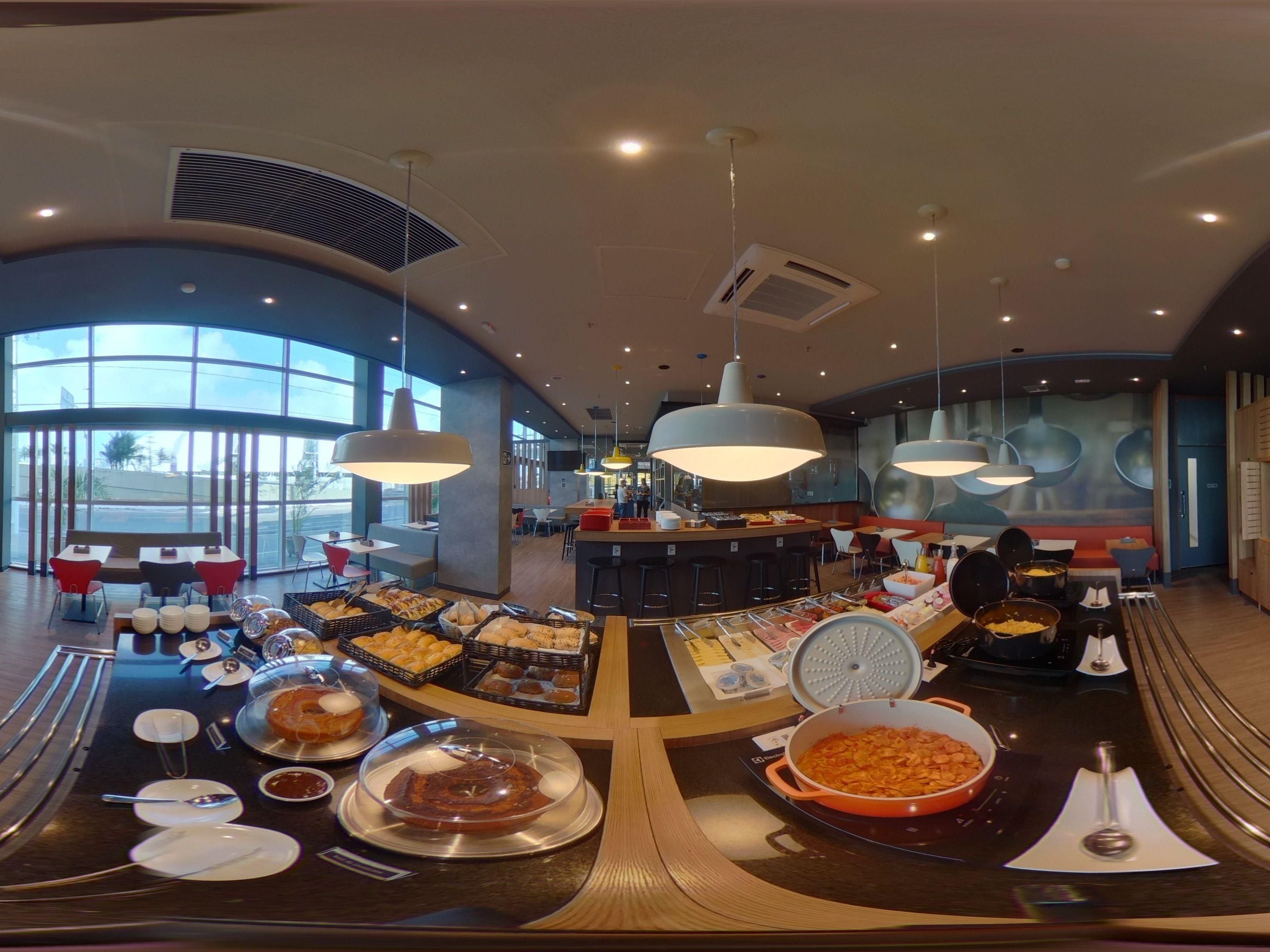 Een buffetopstelling met diverse gerechten en een zithoek met tafels en stoelen.