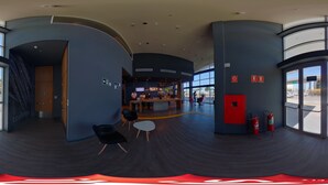 A modern interior with curved walls, a reception area, and large windows.