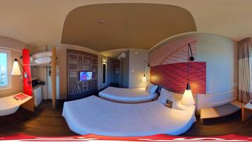 Una habitación de hotel moderna con techo curvo, cama con pared de acento roja, escritorio con lámpara y vista a la ciudad.