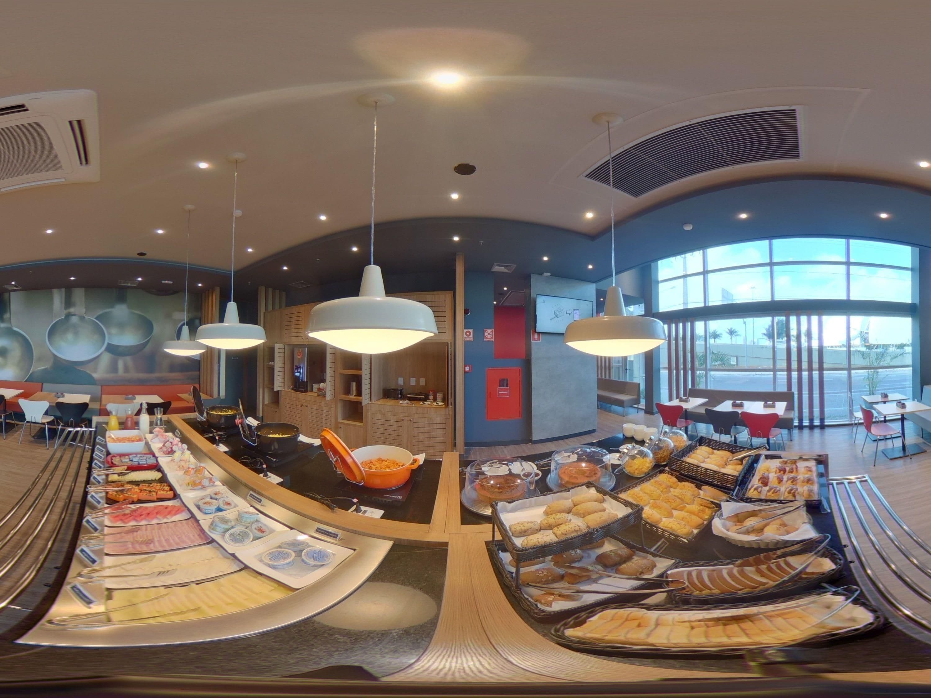 A buffet area with various food items and a seating area with tables and chairs.