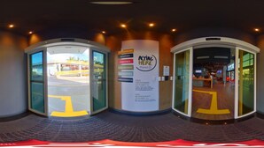A hotel entrance with revolving doors, a reception desk, and a sign promoting Planet 21.