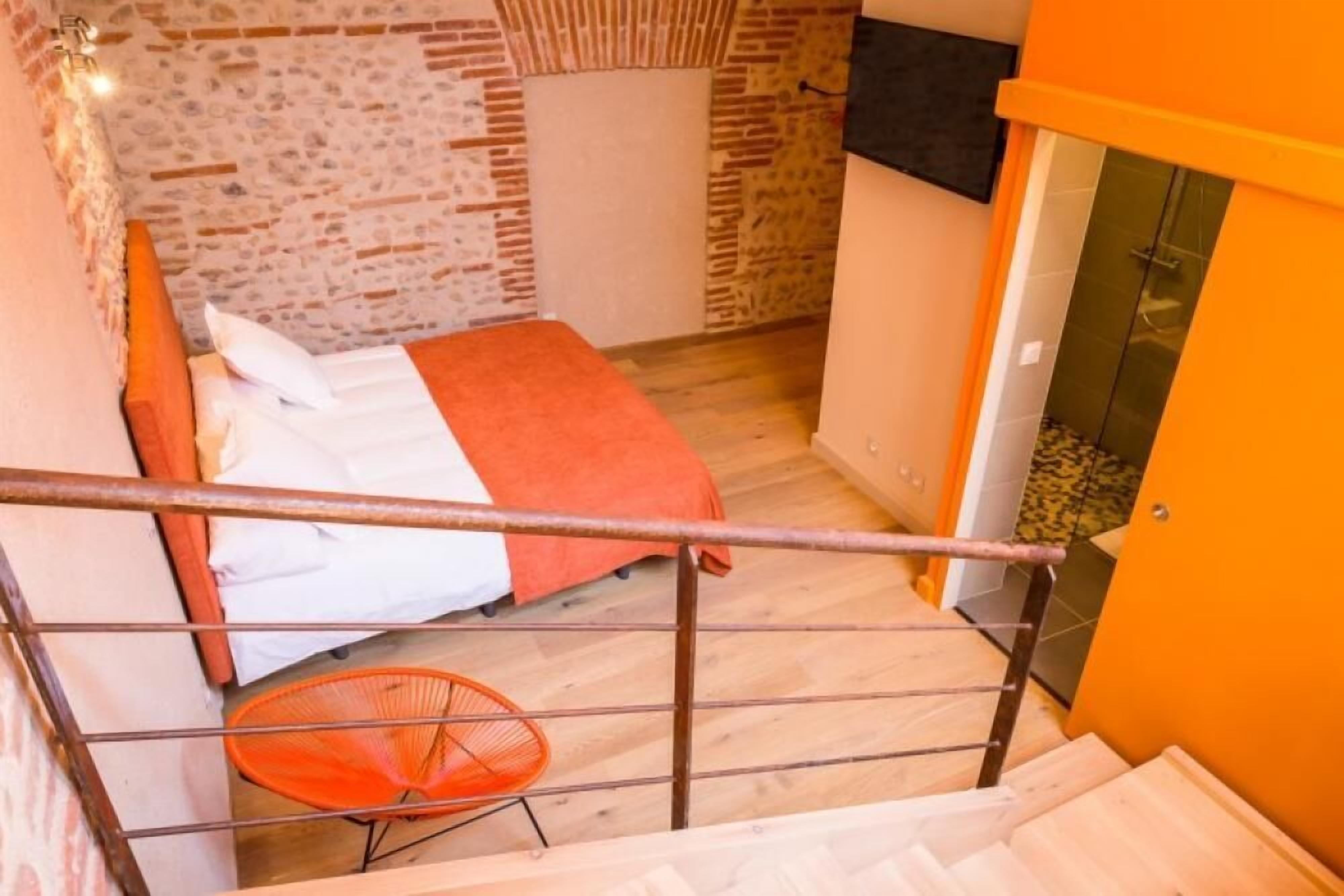 Un dormitorio con cama, una silla y una escalera.