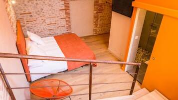 Un dormitorio con cama, una silla y una escalera.