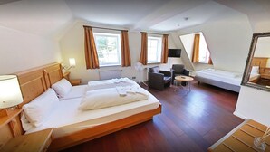 Een hotelkamer met twee bedden, een bureau, een stoel, een televisie en een grote spiegel.