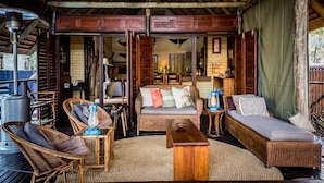 A cozy room with wicker furniture, a wooden table, and a sofa. - Avoca Private Bushcamp (Bushbuckridge)