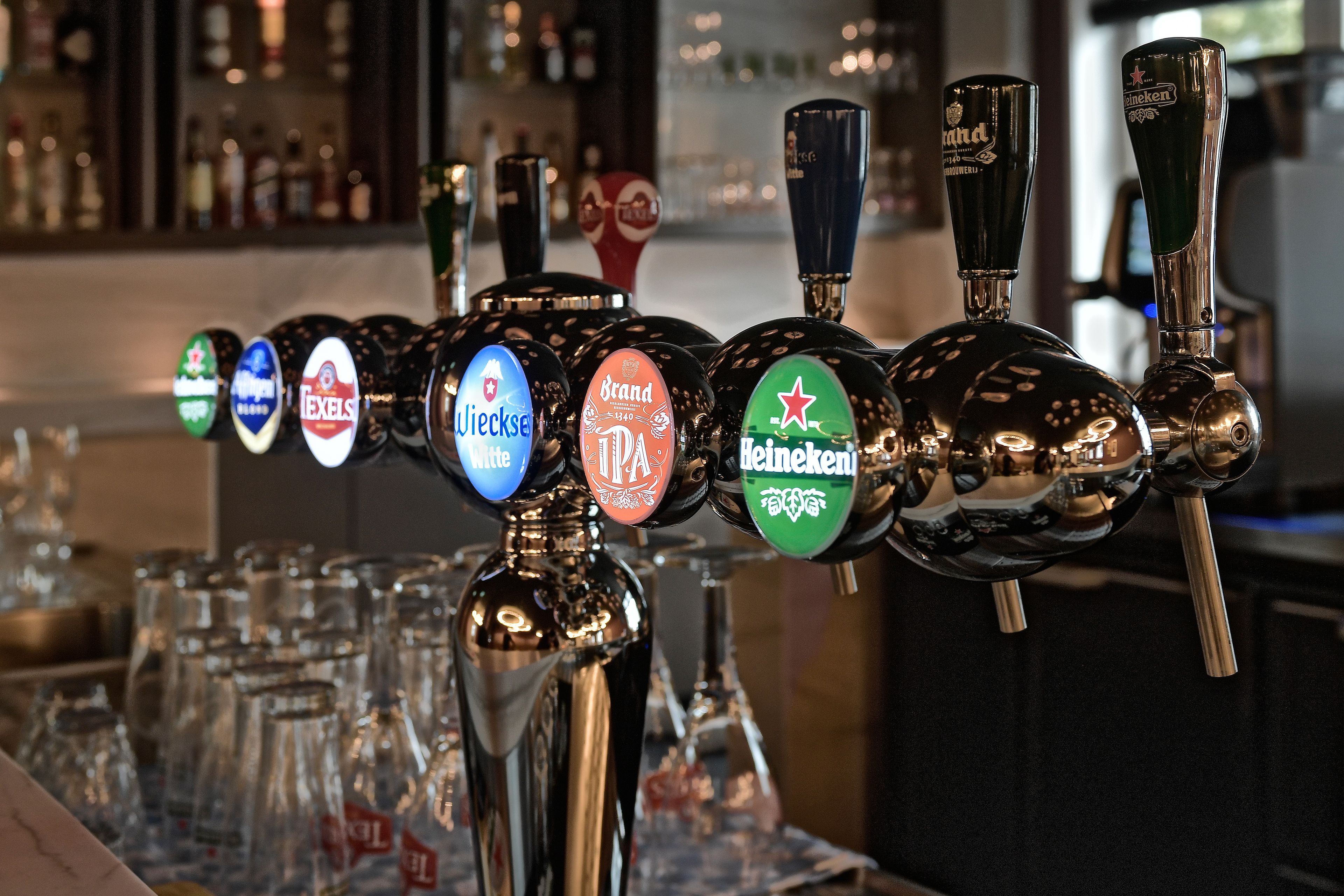 Una hilera de grifos de cerveza con diferentes etiquetas de marca.