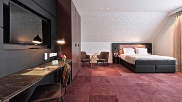 Une chambre d’hôtel équipée d’un lit, d’un bureau, de chaises et d’un téléviseur.