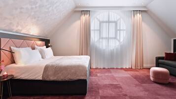 Un dormitorio moderno con una cama grande, una mesita de noche, un sofá y una ventana con cortinas.