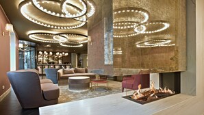 Eine moderne Lobby mit einer Marmorrezeption, bequemen Sitzgelegenheiten und einem Kamin.