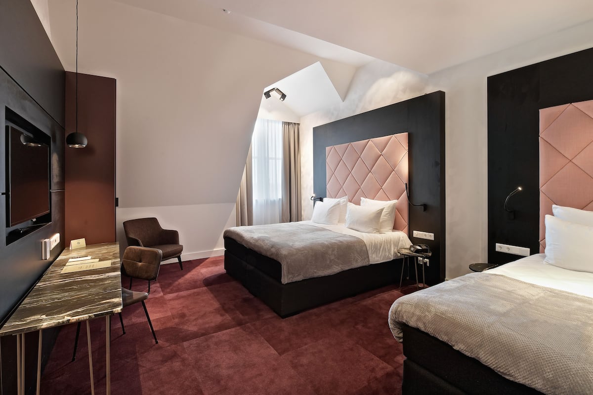 Una habitación de hotel moderna con una cama grande, un escritorio y un televisor.