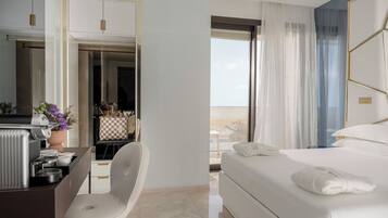 A modern hotel room with a bed, a desk with a chair, a view of the outdoors, and a bathroom with a shower.