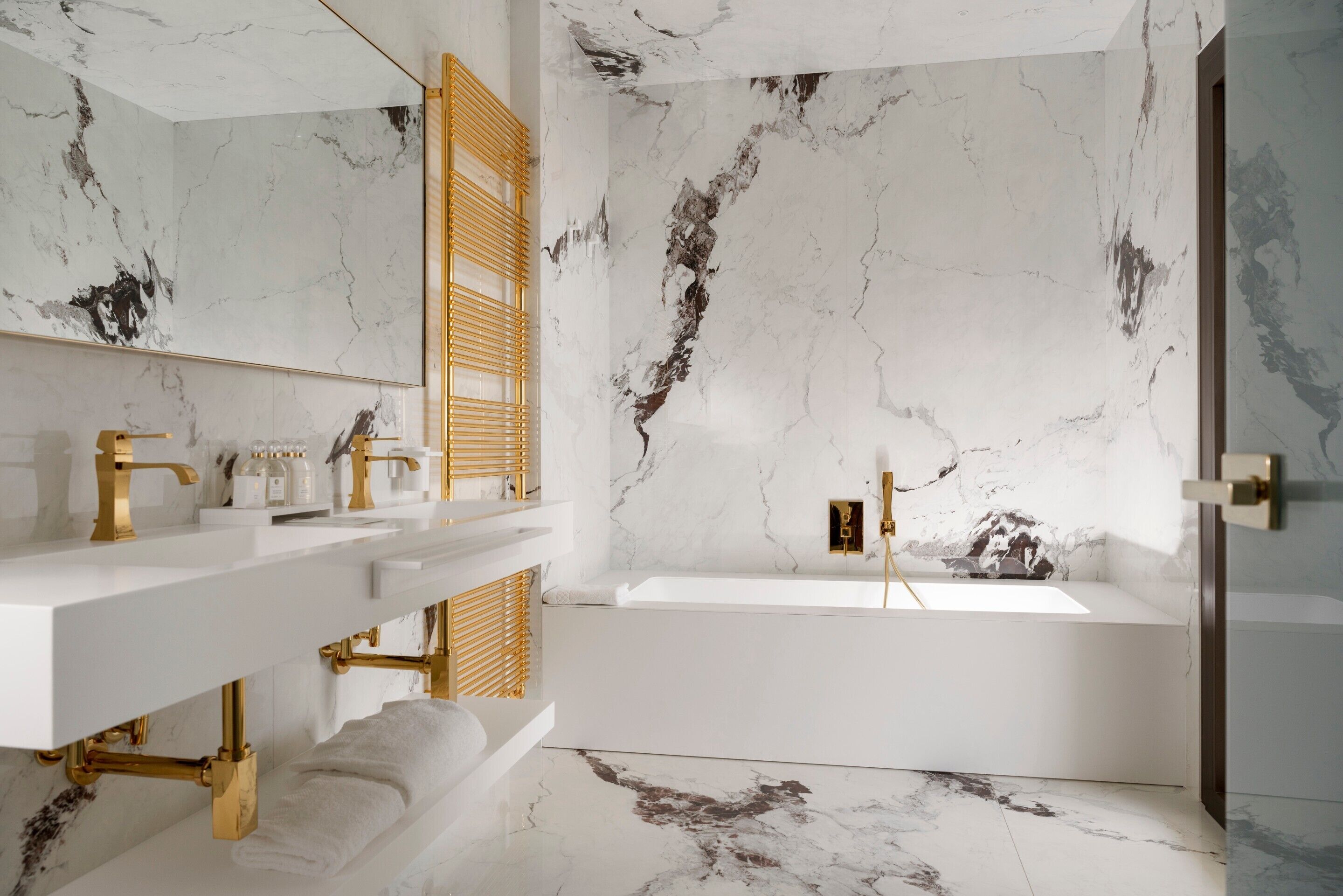 A modern bathroom with marble walls and a bathtub.
