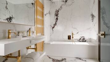 A modern bathroom with marble walls and a bathtub.