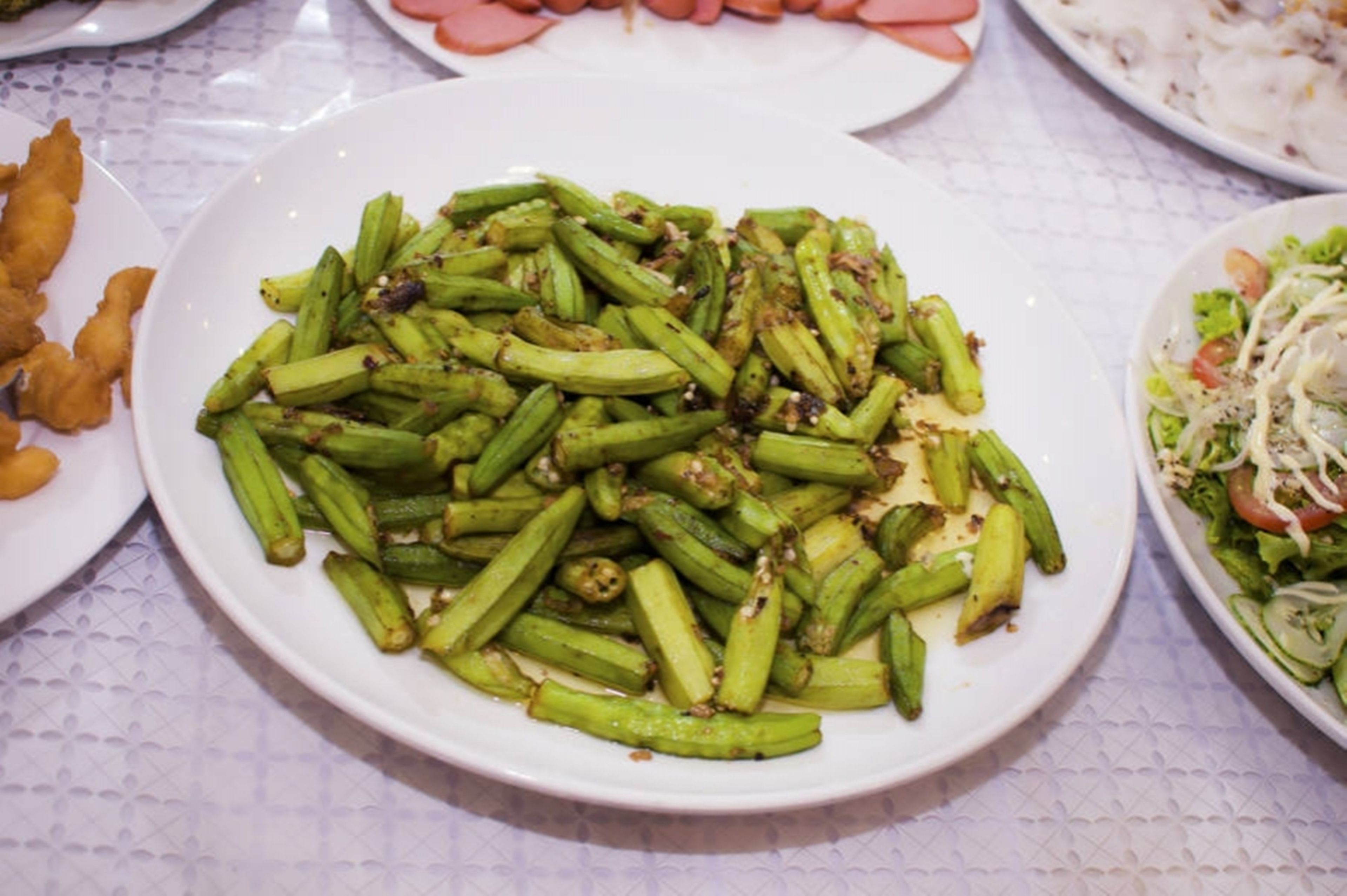 A plate of cooked okra with a white background.