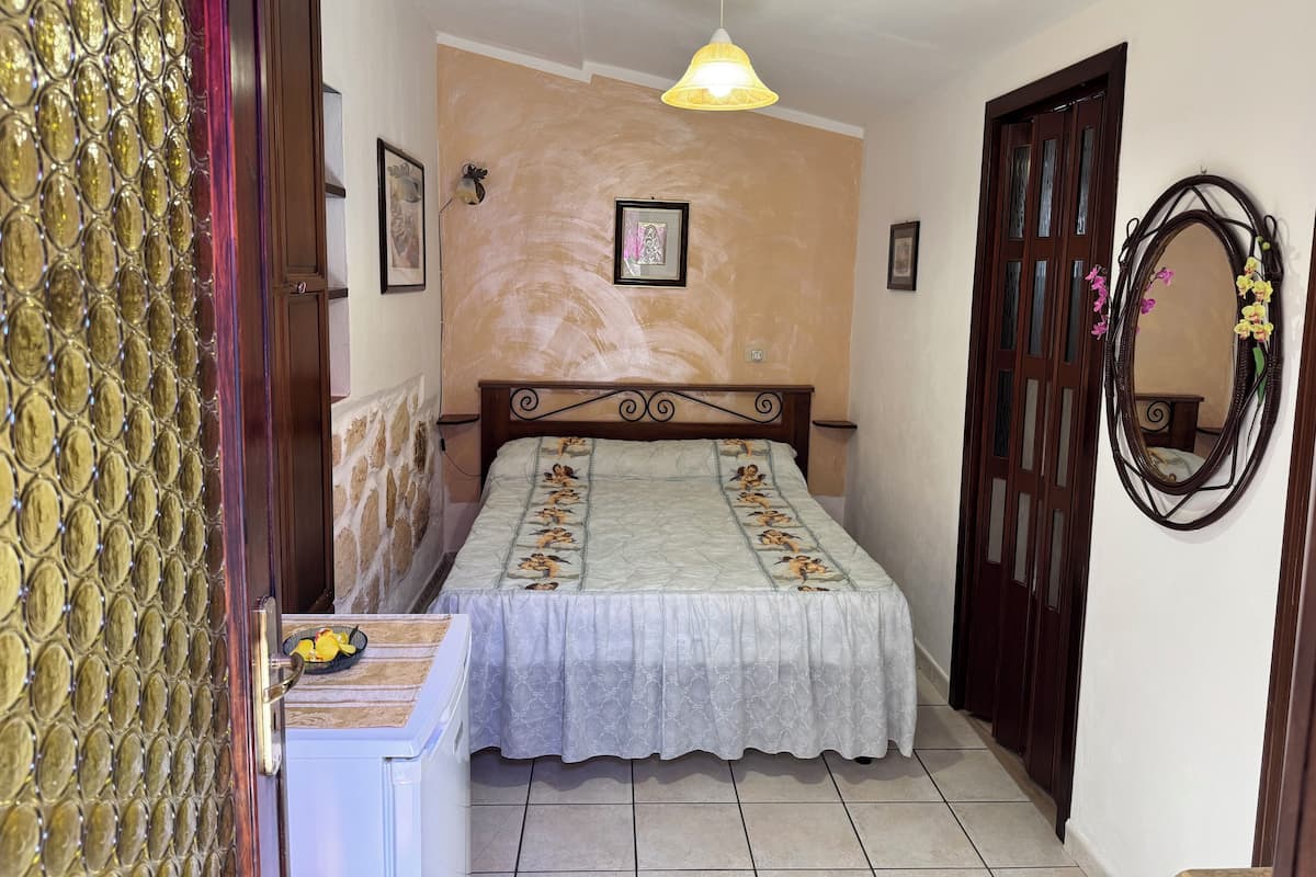Un dormitorio con cama, cómoda, espejo y puerta.