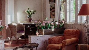 A vintage-style room with a fireplace, wicker furniture, and a dining area.