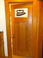 Una puerta de madera con un cuadro enmarcado de hierro.