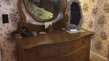 A wooden dresser with a mirror and a crystal on top.