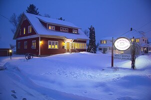 Un edificio cubierto de nieve con un letrero que indica alquileres semanales o mensuales.