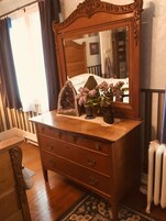 Un aparador de madera con cajones y un espejo encima.
