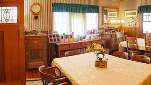 A traditional dining room with a wooden table, chairs, and a clock on the wall. - Old Iron Inn Bed and Breakfast (Caribou)
