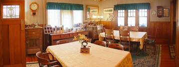 Un comedor tradicional con una mesa de madera, sillas y un reloj en la pared.