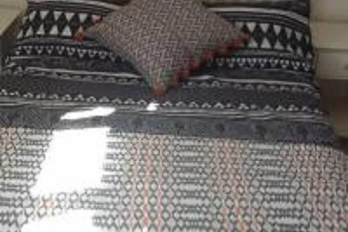 A bed with patterned bedding and pillows.