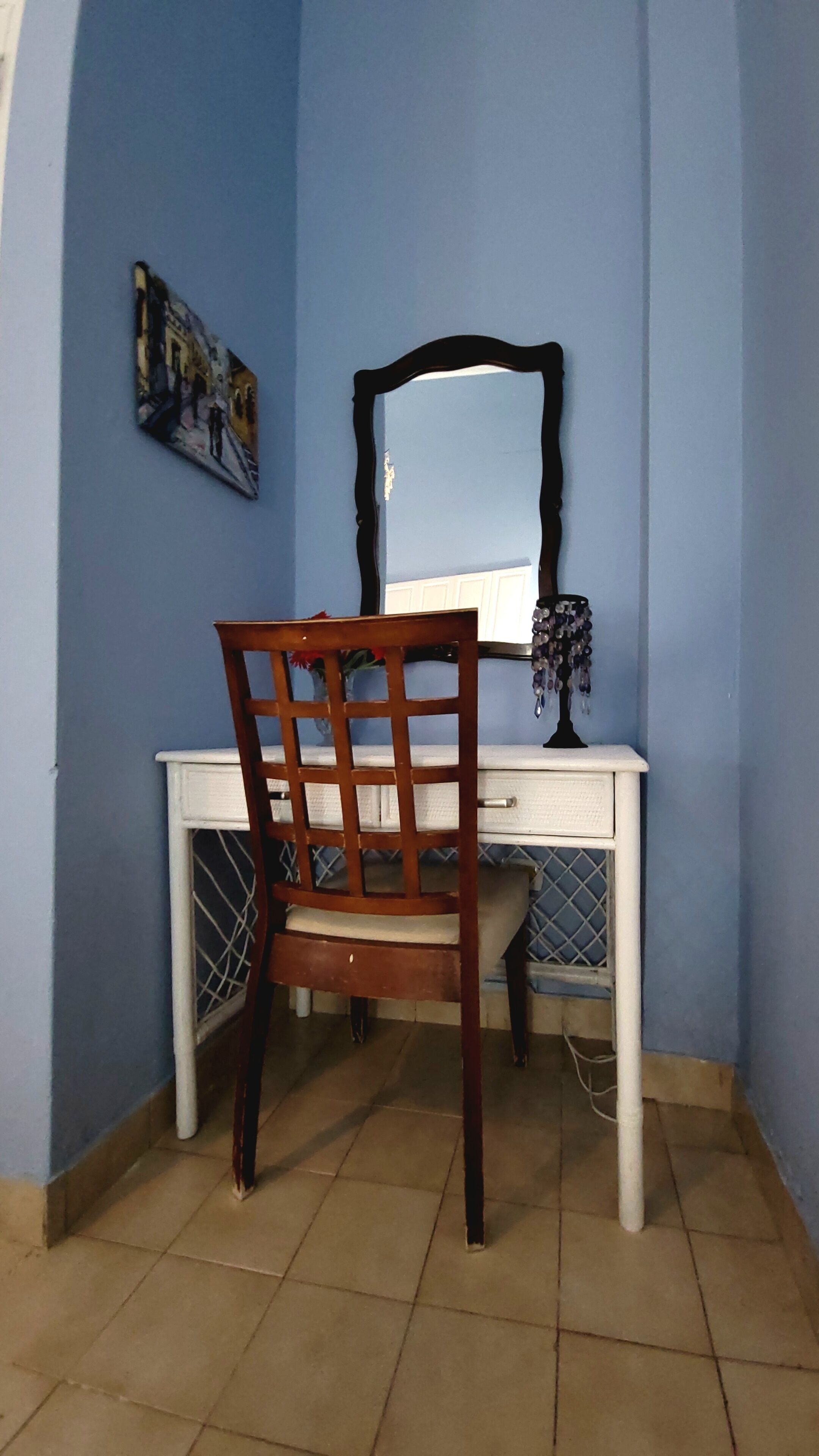 Una habitación con escritorio, silla y espejo.