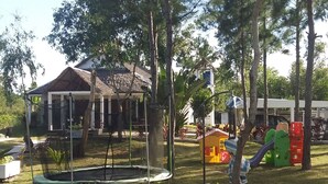 A residential area with a house, a trampoline, and a playground with a slide. - The Sanctuary (Mahavelona)