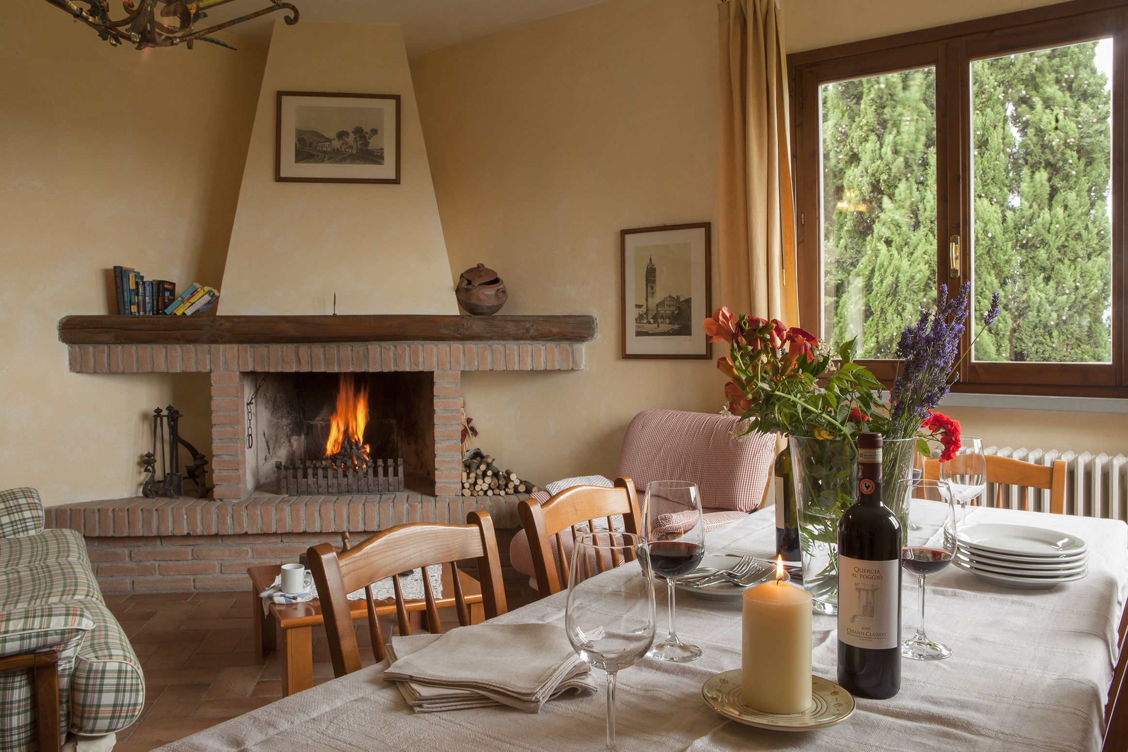 A dining area with a brick fireplace, wooden furniture, and a table set for a meal.