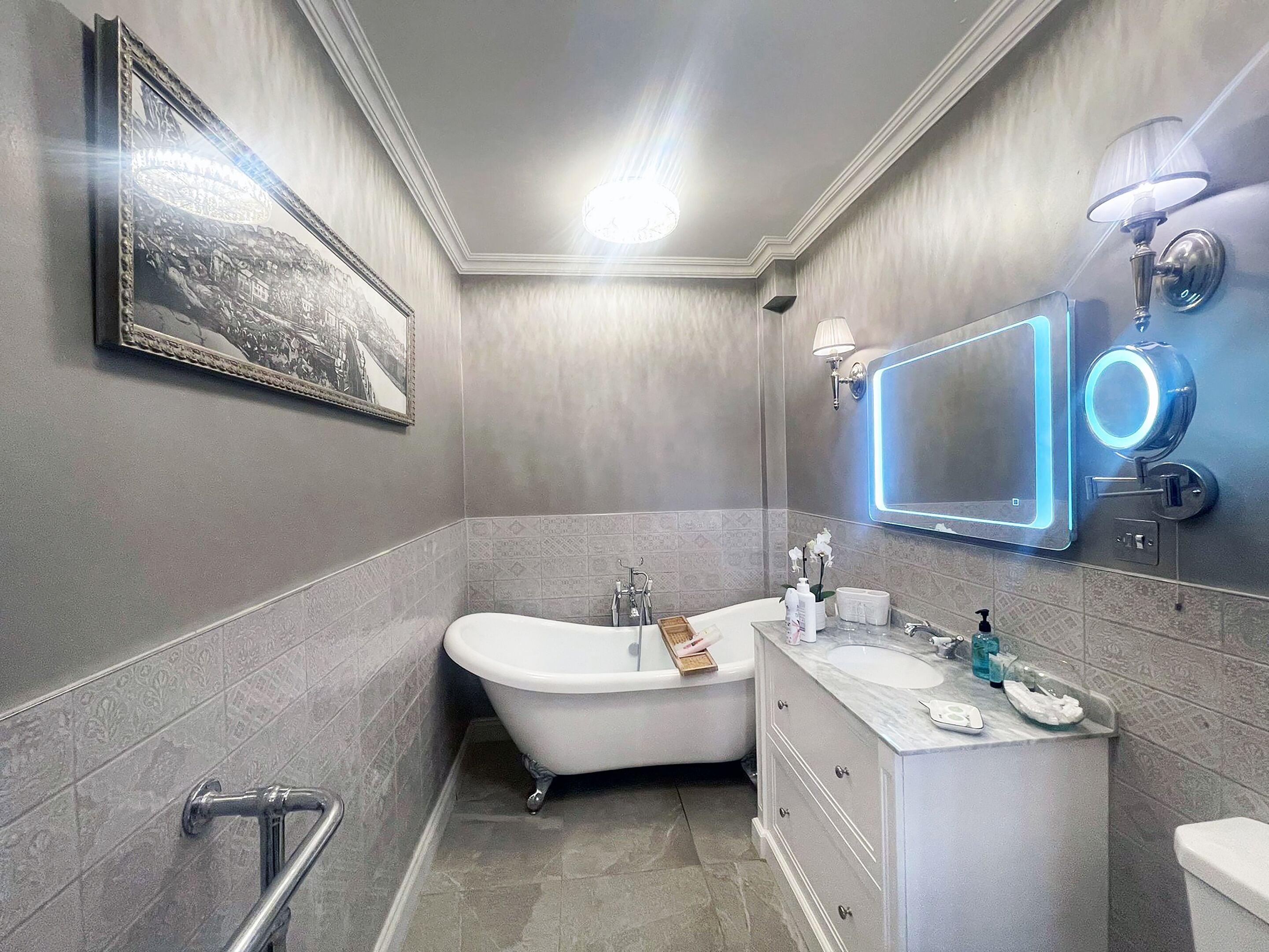 Ein modernes Badezimmer mit einer freistehenden Badewanne, einem Waschtisch inklusive Spiegel und einer Duschkabine.