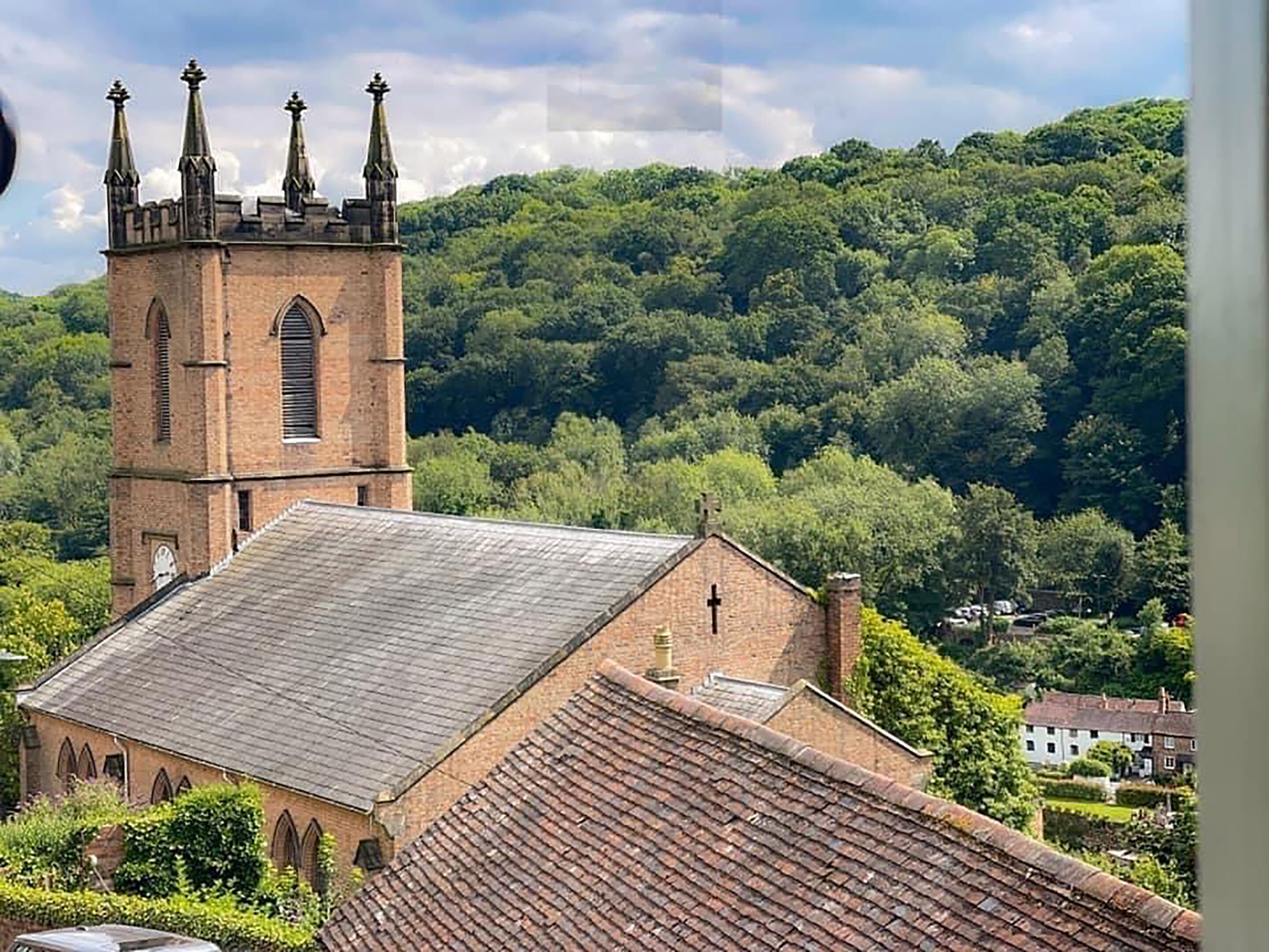 Eine Kirche mit einem markanten Turm und einem Gebäude mit flachem Dach.