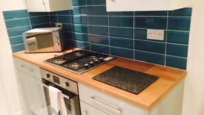 Una cocina compacta con estufa a gas, horno y tostadora.