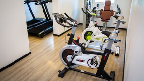 A gym with stationary bikes, a treadmill, and a rowing machine. - Hotel Modular Express Calama (Calama)
