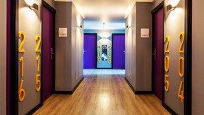 A hotel hallway with wooden flooring and purple walls. - Hotel Modular Express Calama (Calama)