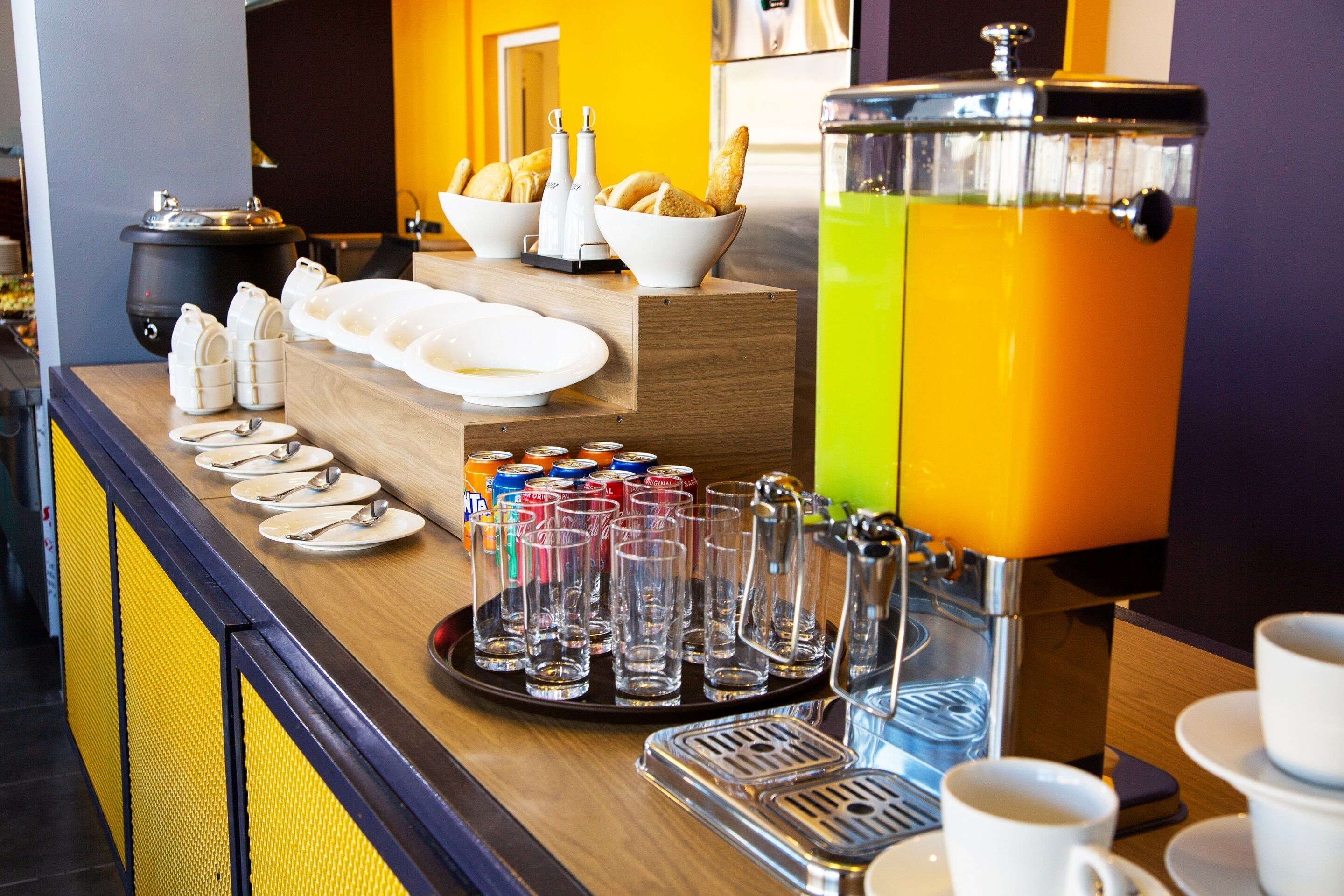A breakfast bar with a coffee machine, bread, and condiments.