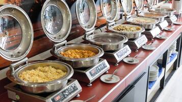Buffet com diversas estações de serviço, cada uma com um prato coberto e um visor digital.