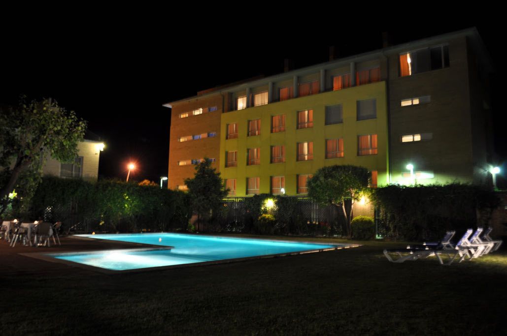 Un hotel con piscina y zona de estar al aire libre.
