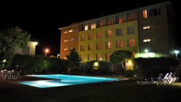 Un hotel con piscina y zona de estar al aire libre.