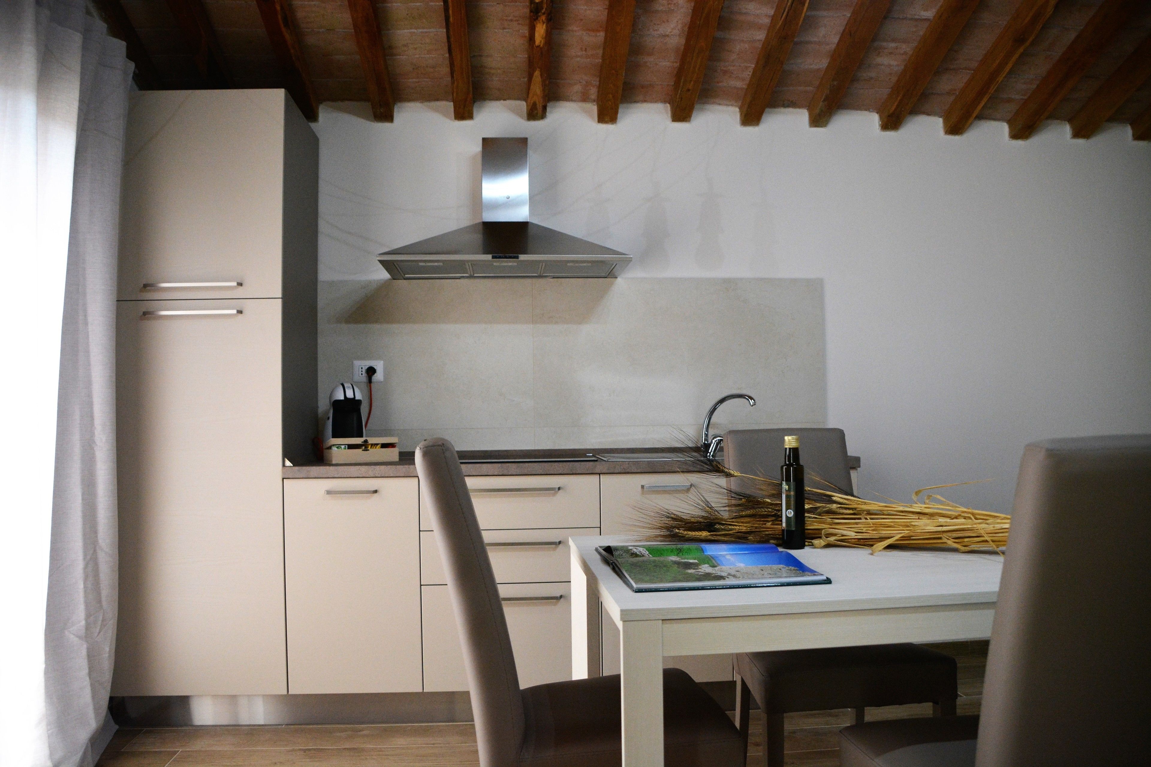 A compact kitchen with a modern stove, a sink, and a dining area with a table and chairs.