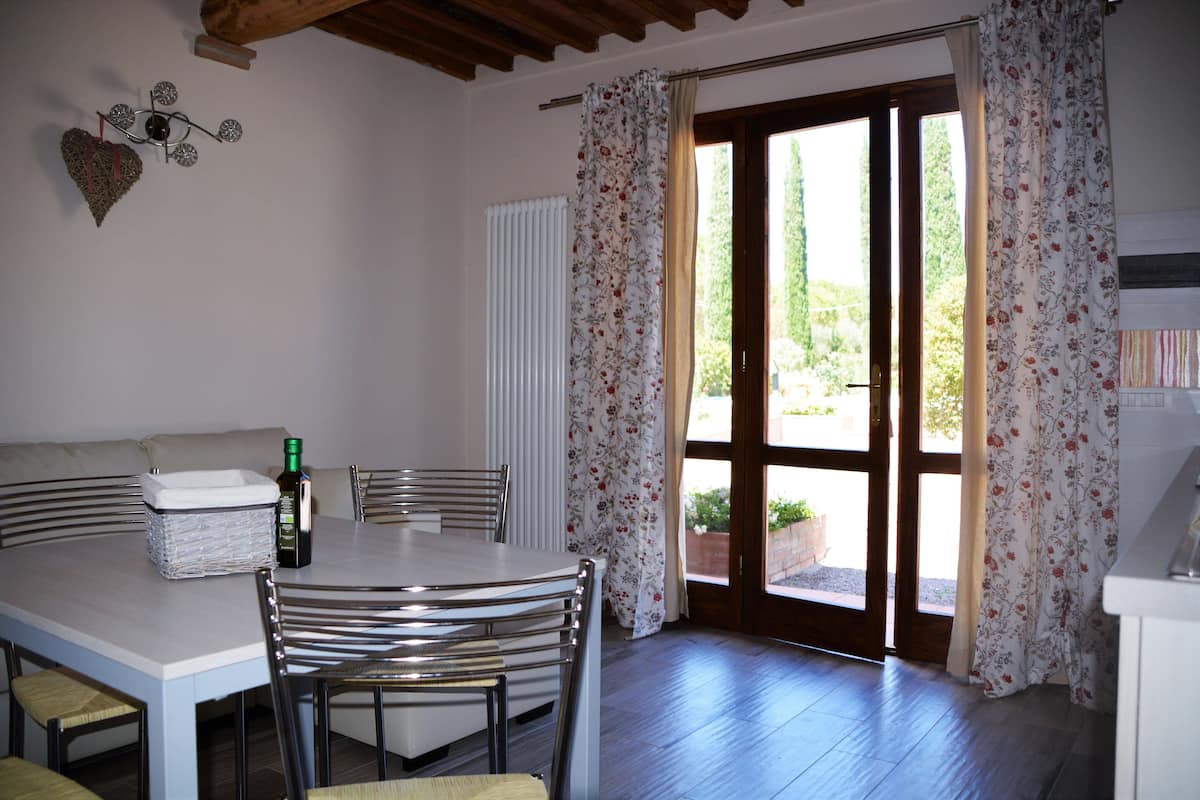 Un espace repas comprenant une table, des chaises, une bouteille et un panier.