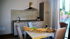 Een moderne keuken met een inbouwfornuis, een gootsteen en een raam met gordijnen.