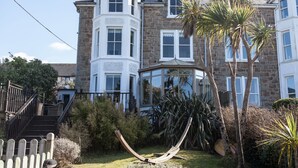 A large stone building with multiple windows, a bay window, and a conservatory. - Headland House Luxury B&B (St Ives)