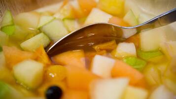 Primer plano de una ensalada de frutas con una cuchara.
