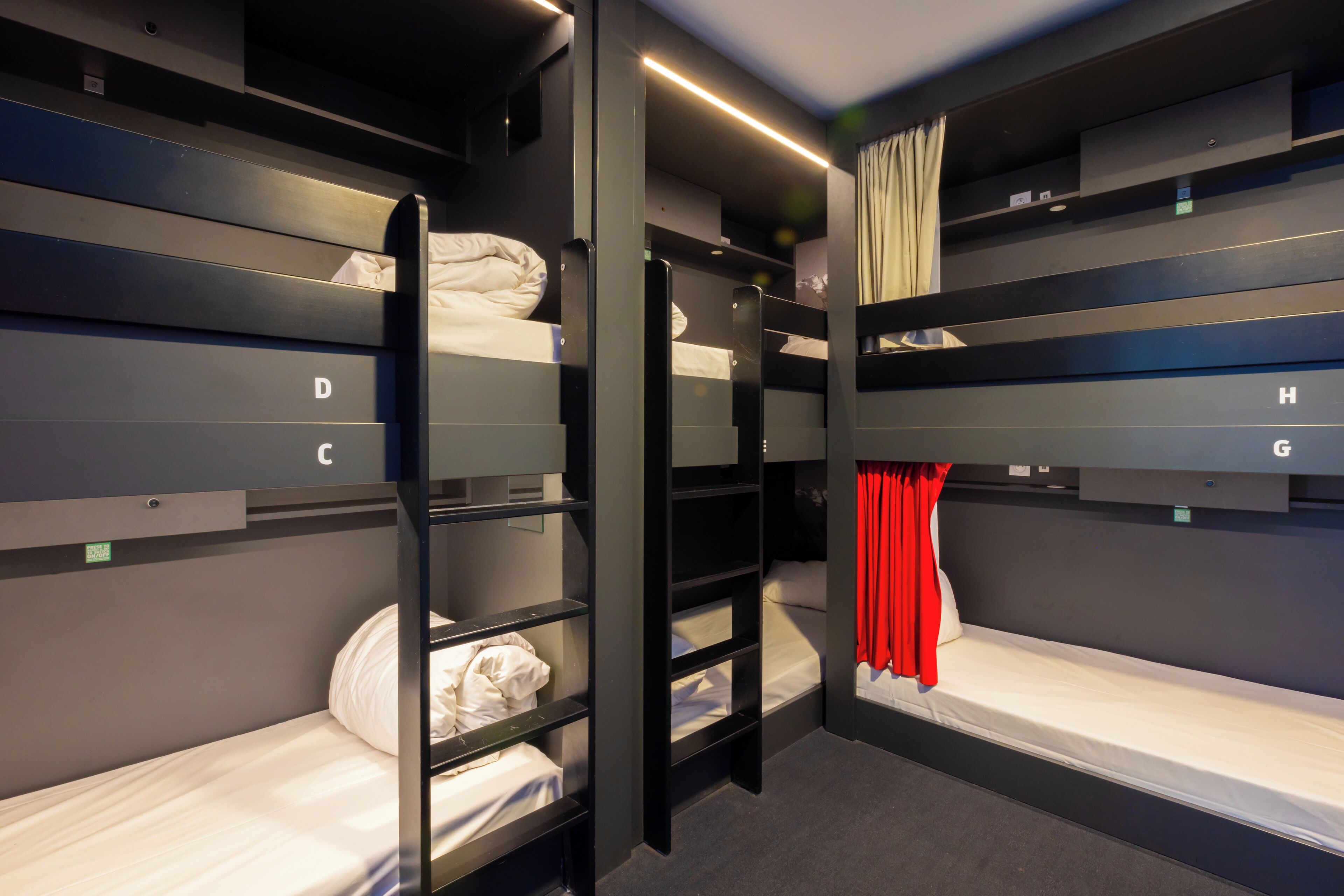 A bunk room with labeled beds D, C, H, and G, and a ladder for access.