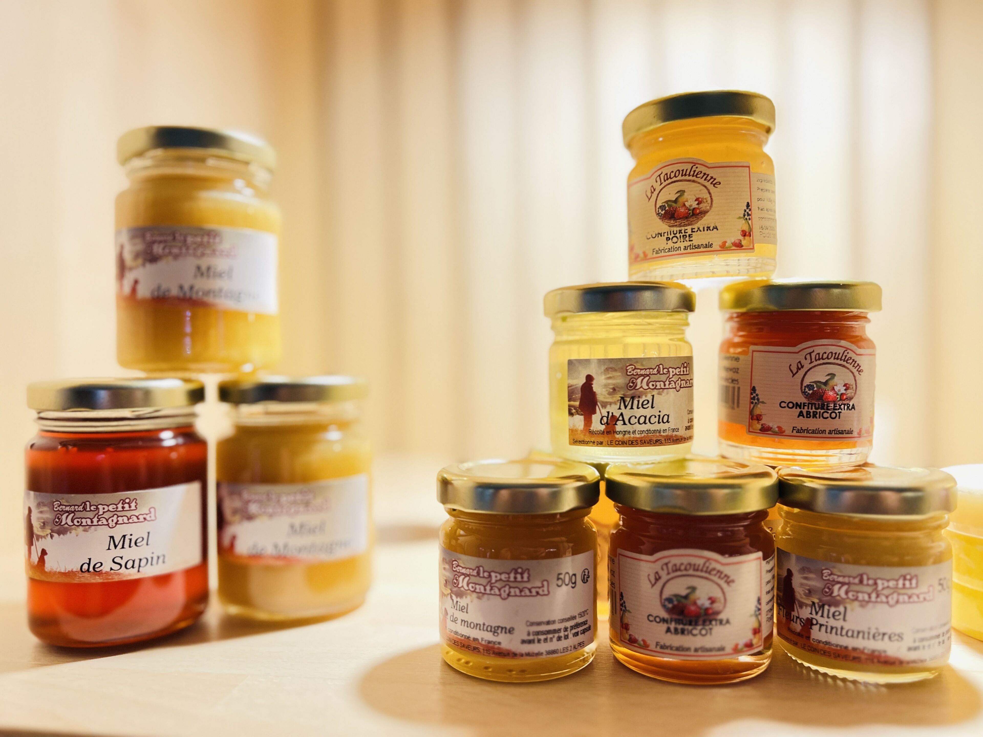 Several jars of honey on a table.