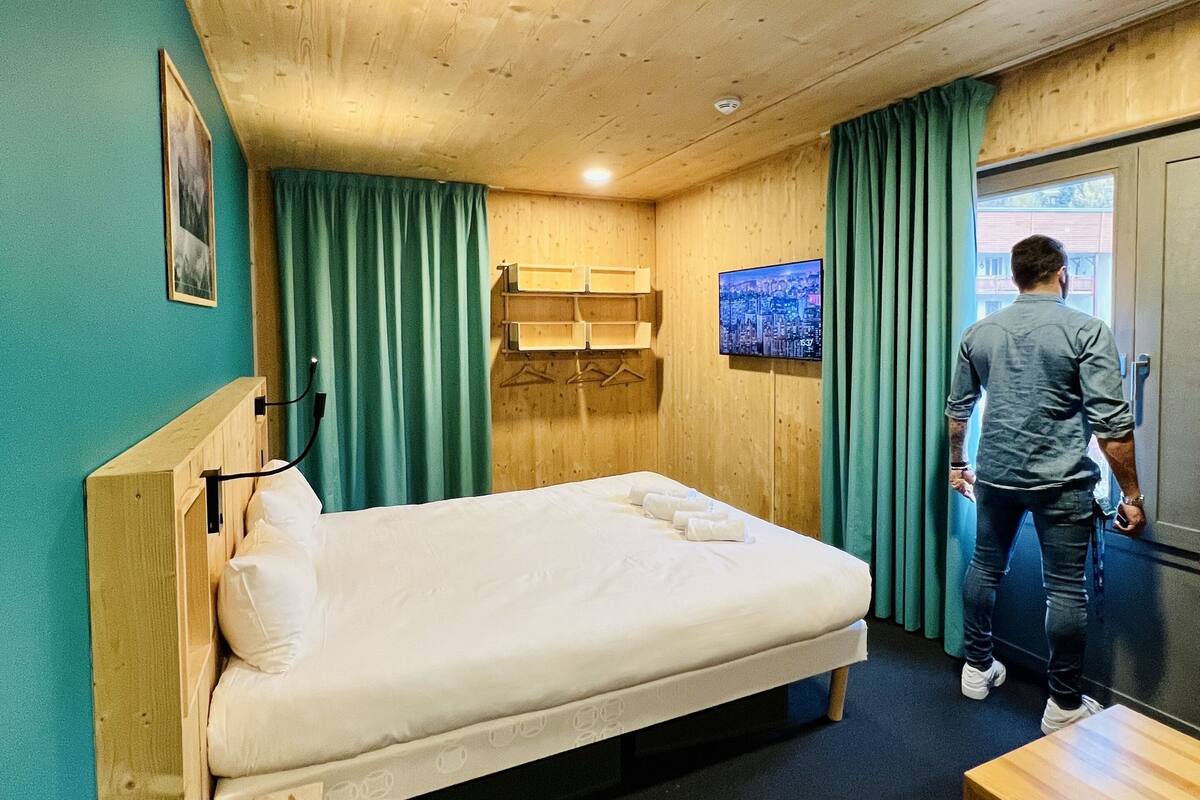 Une pièce en bois avec un lit, une télévision et une fenêtre.