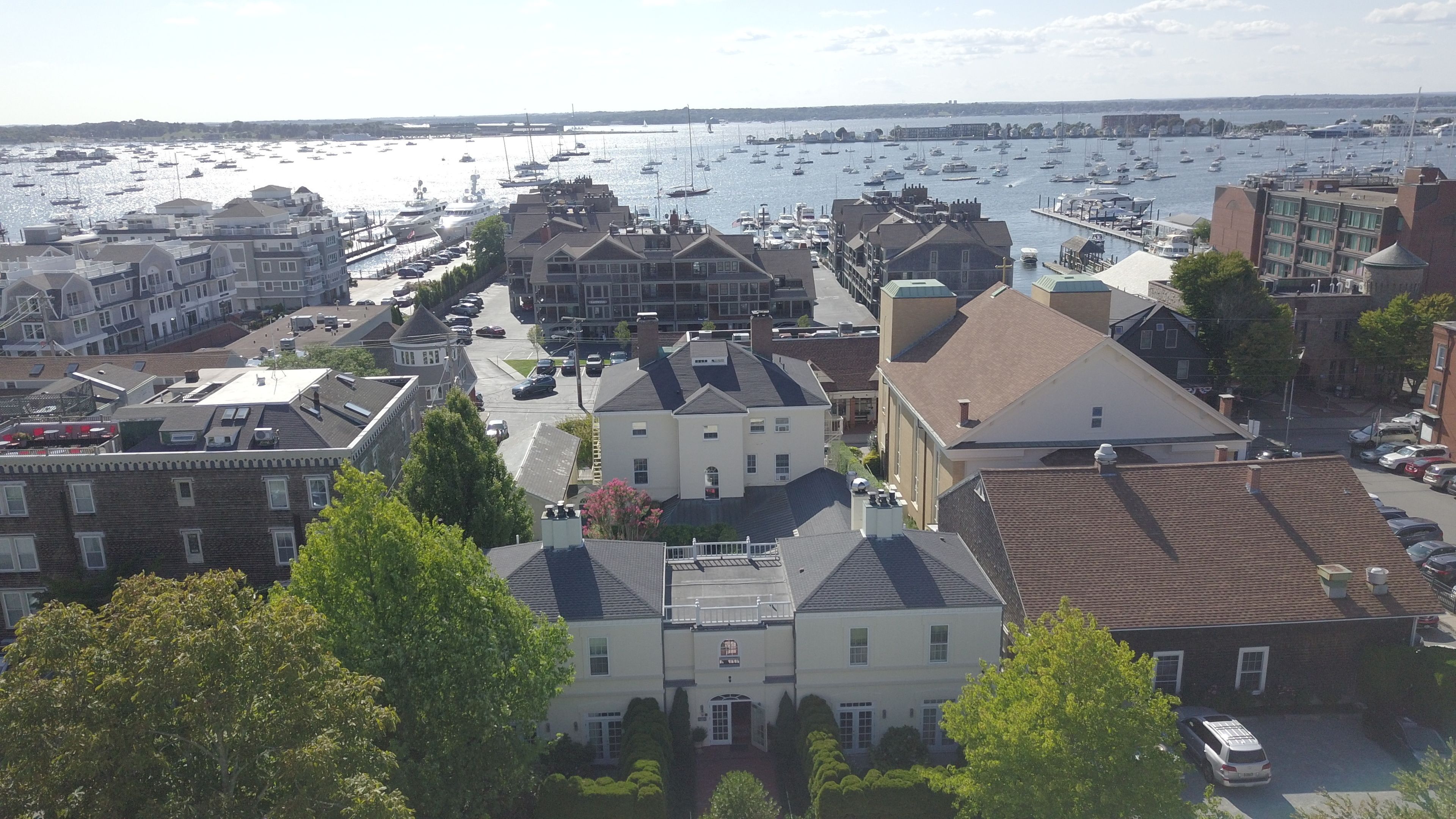 A coastal town with a marina filled with boats, historic buildings, and a mix of residential and commercial structures.
